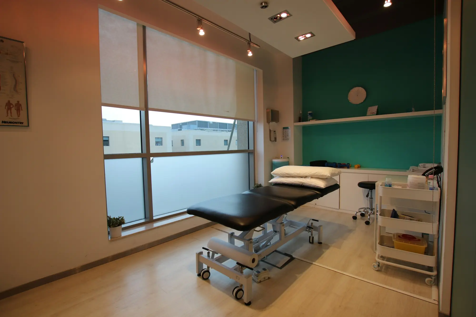 Sala de fisioterapia con camilla, luminosa y ordenada