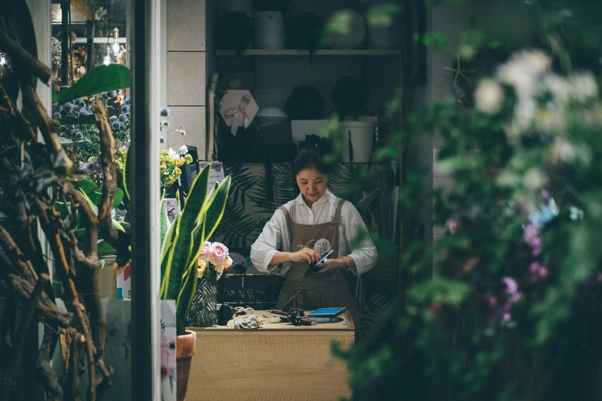 Florista trabajando en el mostrador de su tienda