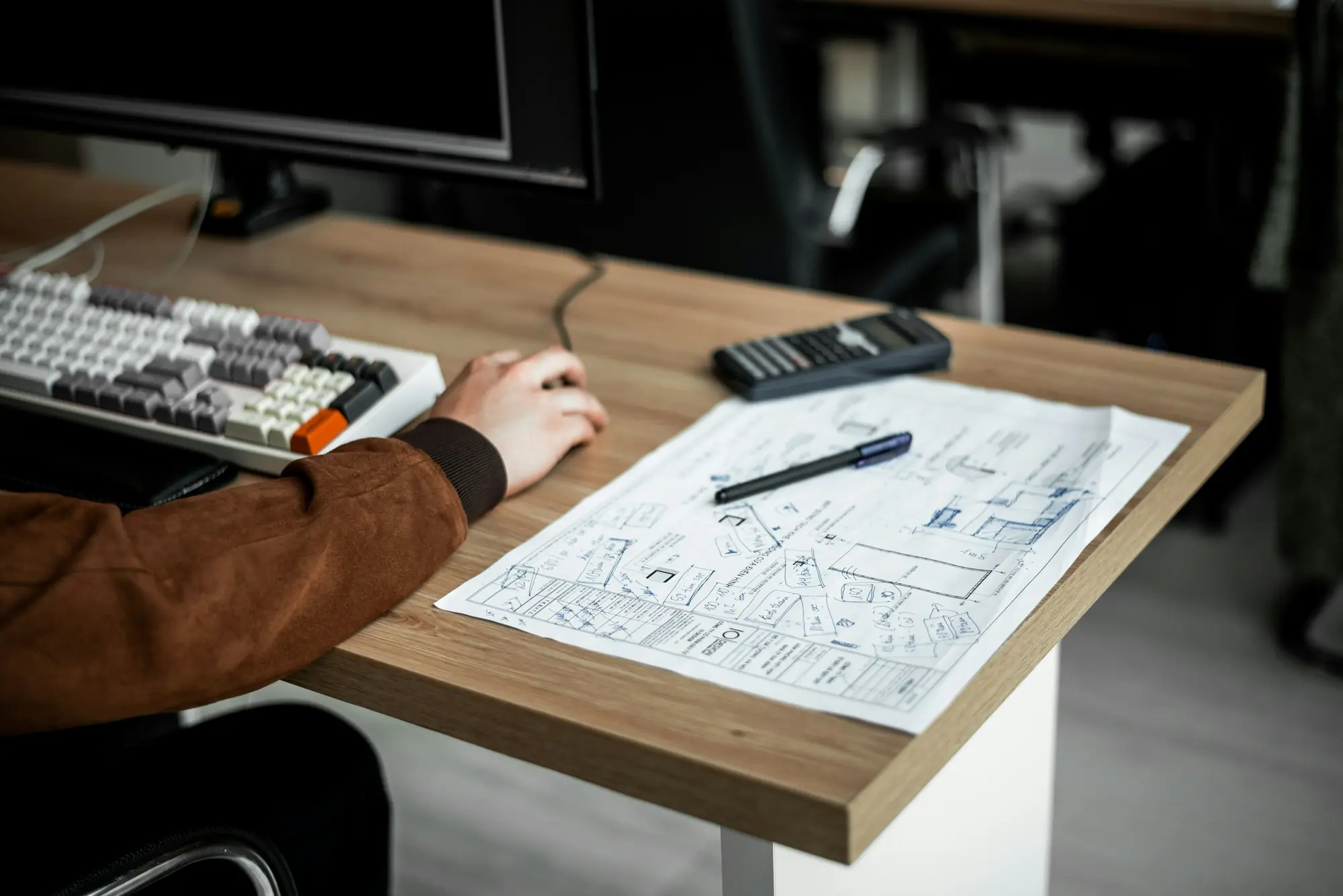 Mesa de estudio con planos, teclado y calculadora